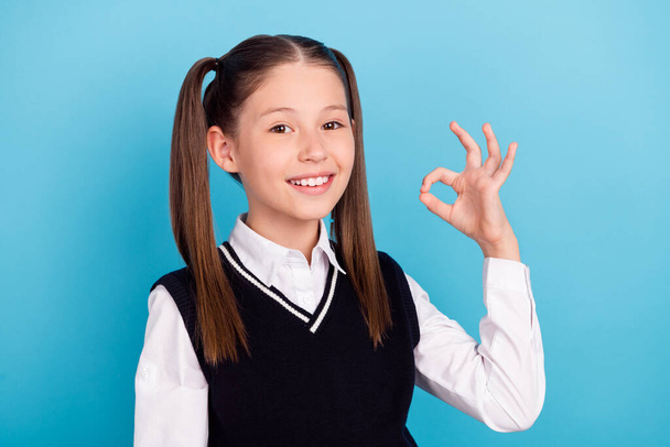 Photo of cool small brunet girl show okey wear white shirt vest isolated on blue color background. - Fotoğraf, Görsel