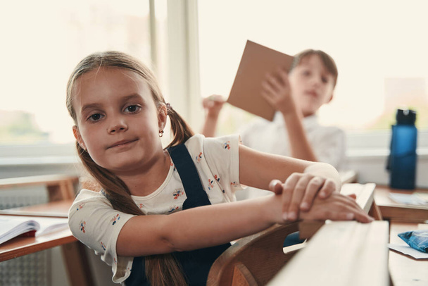 Selbstbewusstes Kind posiert im Klassenzimmer - Foto, Bild