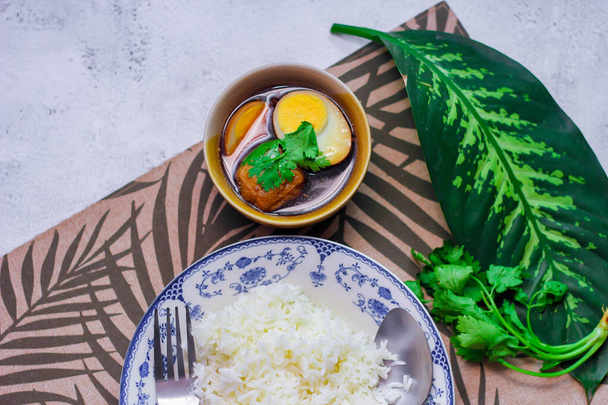 Arroz al vapor en un plato antiguo y huevos cocidos, comida tailandesa y comida callejera que son comunes en Tailandia. - Foto, imagen