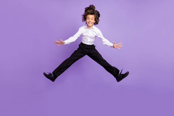 Full body photo of funny little brunet garçon saut porter chemise pantalon baskets isolé sur fond de couleur pourpre - Photo, image