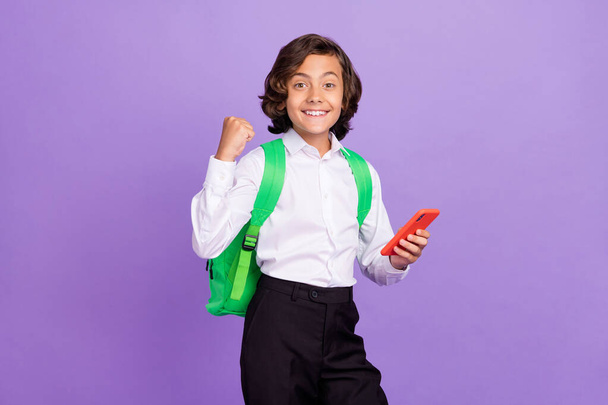 Photo of hooray small brunet boy hold telephone wear formalwear bag isolated on purple color background - Photo, Image