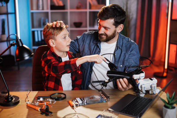 Boy with father fixing quadcopter together - Fotoğraf, Görsel