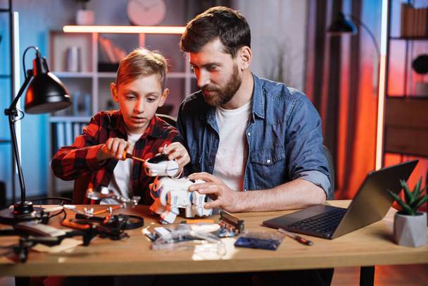 Father helping his son to repairing toy robot dog - Foto, Imagem