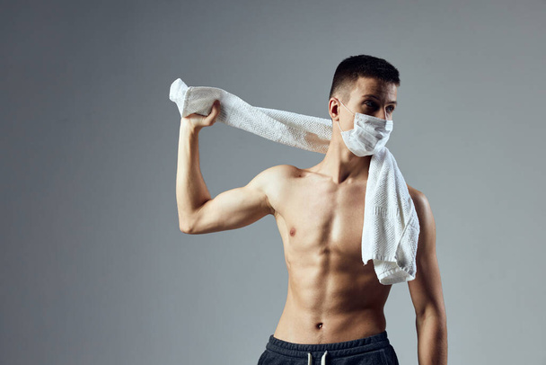 спортивный человек медицинская маска полотенце на плечах культурист  - Фото, изображение