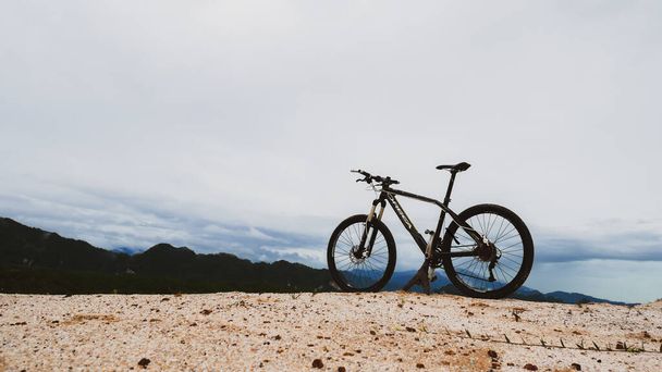 美しい景色を望む山の上に駐輪する自転車, 2021年8月6日,タイ,スラッタニー. - 写真・画像