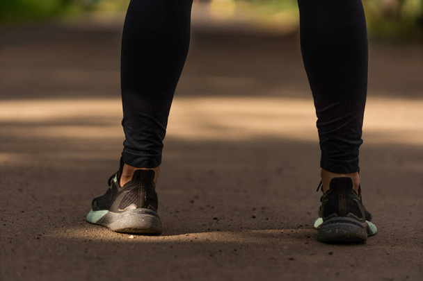 Loopvoeten rennend op weg close-up op schoen. vrouw fitness sunrise jog training welness concept. - Foto, afbeelding