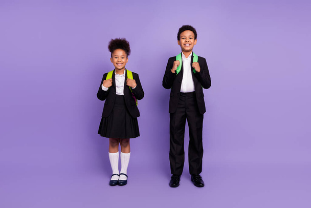 Photo of two african people small schoolkids toothy smile wear backpack uniform isolated violet color background - Foto, Bild