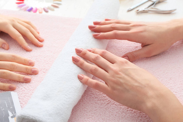 Manicure master working with female client in beauty salon, closeup - Photo, Image