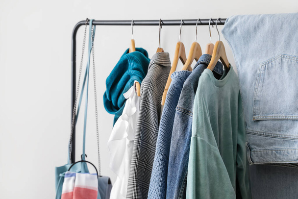 Rack with stylish clothes near light wall - Foto, Imagen