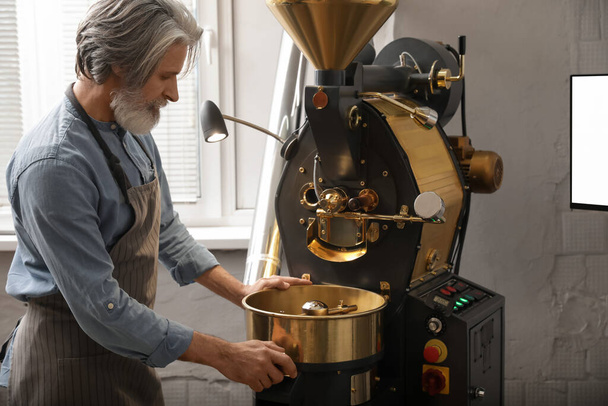 Senior man met moderne koffiebranderij - Foto, afbeelding