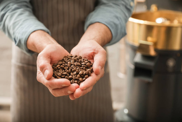 Senior man holding coffee beans, closeup - Фото, изображение