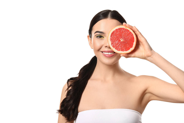Красивая молодая женщина с грейпфрутом на белом фоне - Фото, изображение