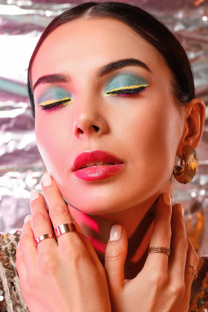 Красивая молодая женщина со стильным макияжем на цветном фоне - Фото, изображение