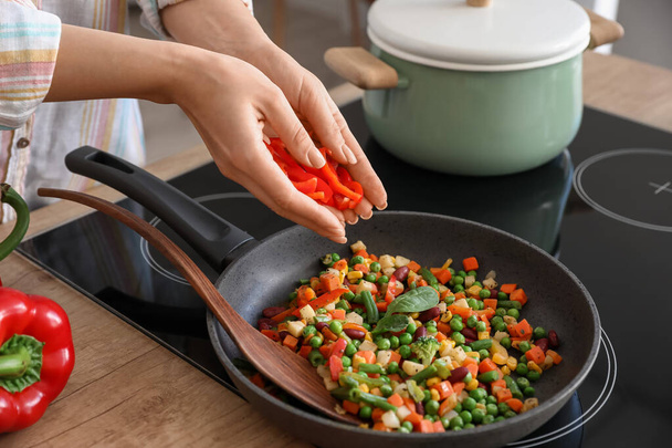 Nainen paistamiseen vihanneksia keittiössä - Valokuva, kuva