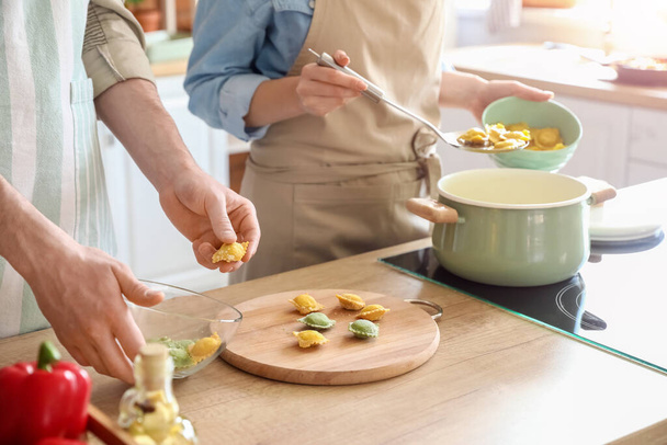 Casal jovem cozinhar ravioli saboroso na cozinha - Foto, Imagem