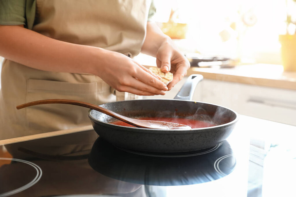 Femme préparant la sauce tomate dans la cuisine - Photo, image
