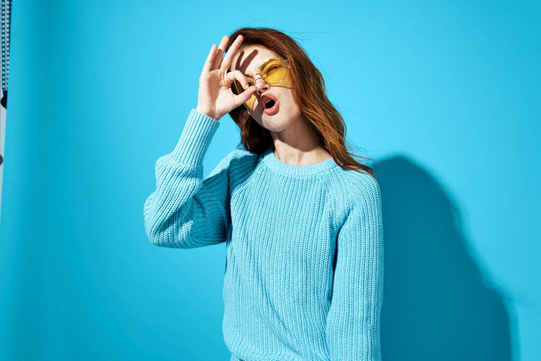 woman in a blue sweater blue background - Photo, Image
