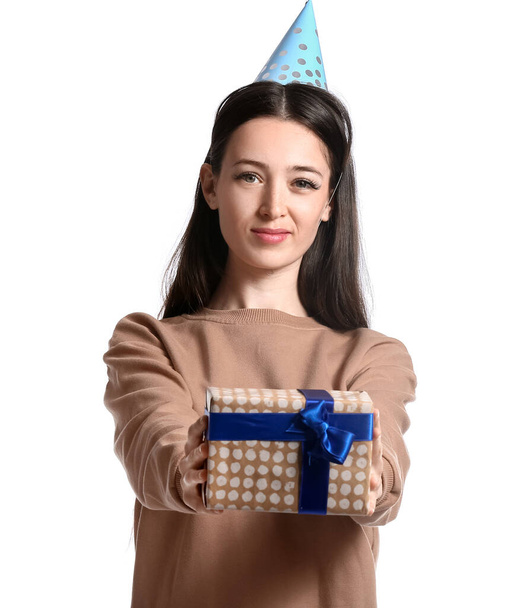 Νεαρή γυναίκα γιορτάζει γενέθλια σε λευκό φόντο - Φωτογραφία, εικόνα