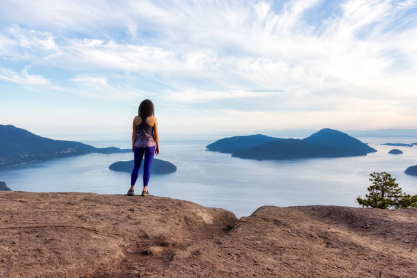 Adventurous Woman Hiking on top of Mountain Landscape - Фото, зображення