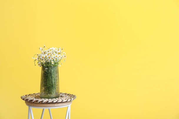 Vaso com belas camomilas na mesa perto da parede de cor - Foto, Imagem