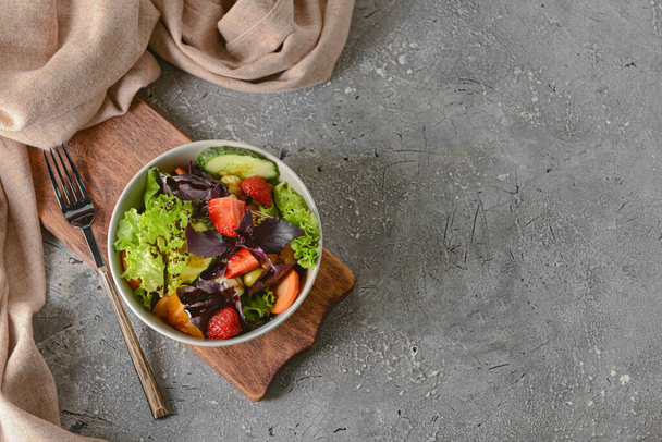 Bowl with tasty fresh salad on grunge background - Foto, Bild