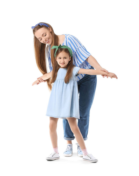 Dancing young woman and her little daughter on white background - Φωτογραφία, εικόνα