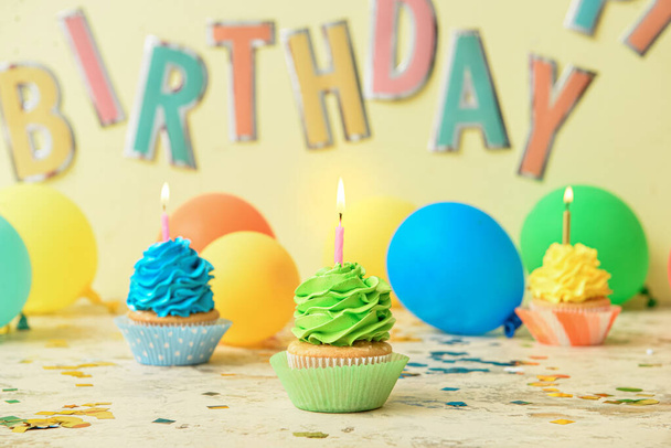 Gustosi cupcake di compleanno con candele accese sul tavolo - Foto, immagini