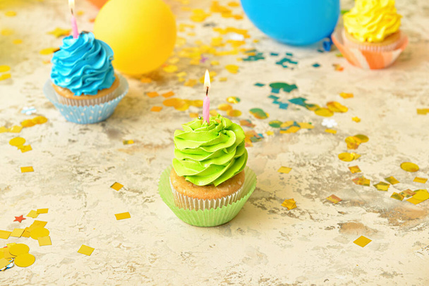 Sabrosos cupcakes de cumpleaños con velas encendidas sobre fondo grunge - Foto, imagen
