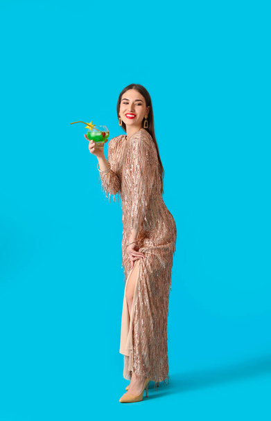 Красивая молодая женщина с коктейлем на цветном фоне - Фото, изображение