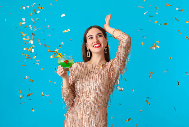 Beautiful young woman with cocktail on color background - Foto, afbeelding