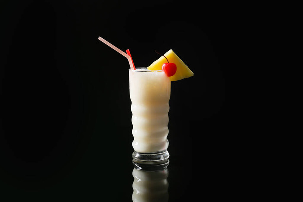 Verre avec savoureux cocktail Pina Colada sur fond sombre - Photo, image