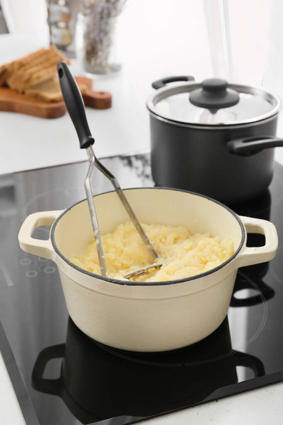 Pot avec savoureuses purées de pommes de terre sur cuisinière électrique à la cuisine - Photo, image