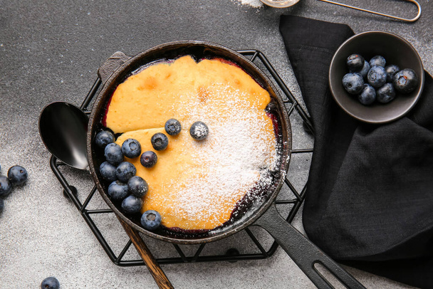 Τηγάνι τηγανίσματος με τάρτα βατόμουρο σε γκρι φόντο - Φωτογραφία, εικόνα