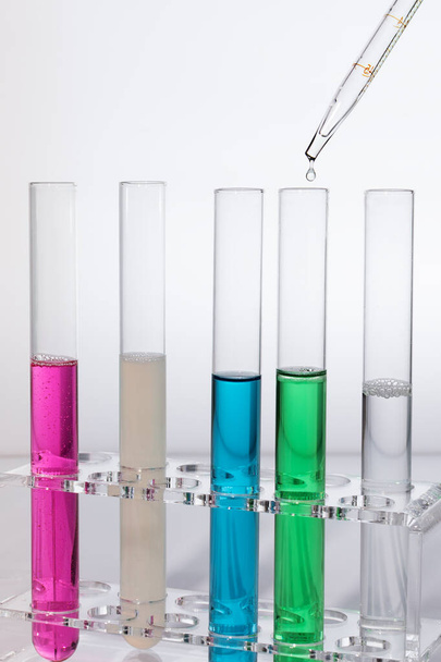 Laboratóriumi kémcsövek színes reagensekkel és cseppes pipettával. Orvosi kutatási fogalom. Laboratóriumi berendezések . - Fotó, kép