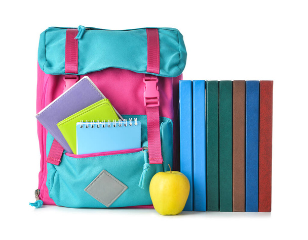 Zaino scuola, libri e mela su sfondo bianco - Foto, immagini