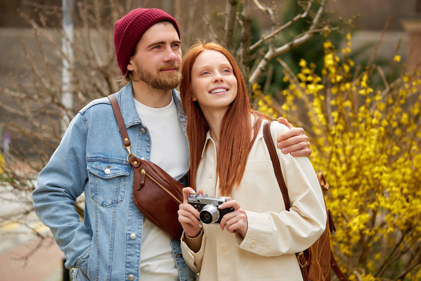 casal casado viajantes em roupa casual passeio na floresta de primavera ou outono, com câmera retro - Foto, Imagem