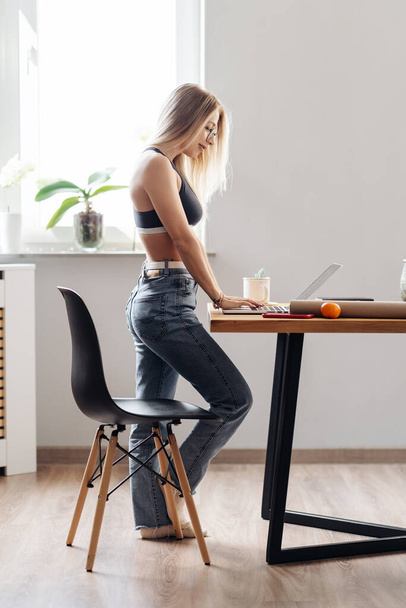 Modern meisje ontspannen op keuken surfen internet - Foto, afbeelding