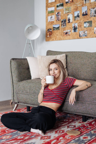 Közelkép fiatal nő iszik teát otthon - Fotó, kép