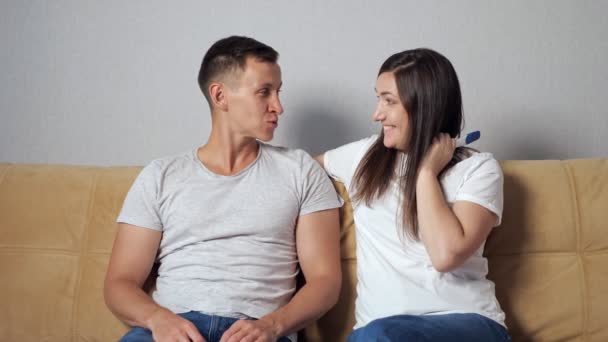若い女性がソファに座ってる男に妊娠検査をした。夫は父になるのがとても嬉しい - 映像、動画