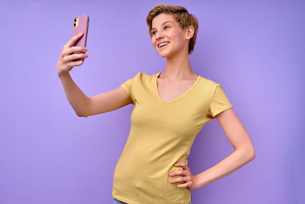 Vue de côté Portrait de positif heureux caucasien femme prenant des photos sur Smartphone - Photo, image