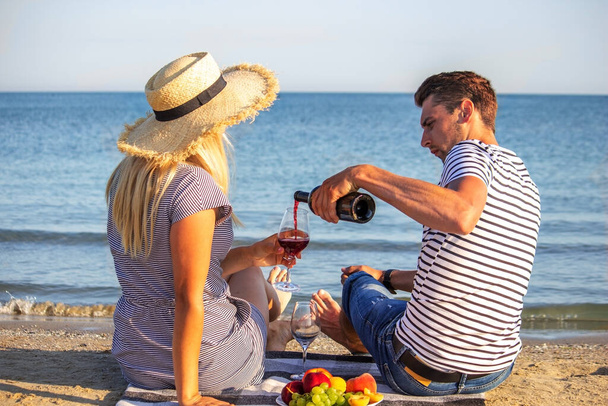Romantic couple enjoying wine by the sea. Selective focus - Zdjęcie, obraz