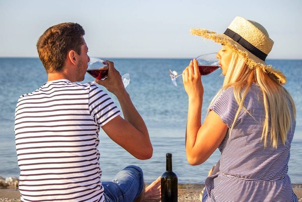Deniz kenarında şarap içen romantik bir çift. - Fotoğraf, Görsel