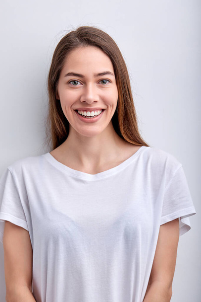 Dobře vypadající žena v ležérní oblečení Při pohledu na kameru roztomile se usmívá, izolované na bílém - Fotografie, Obrázek