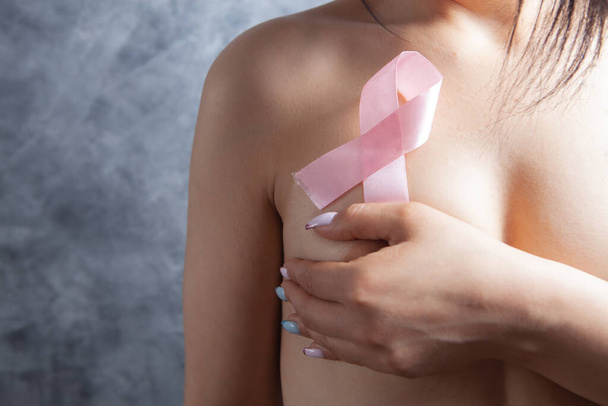 naked woman covered her hand holding a pink ribbon - Photo, Image
