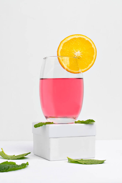  a pink lady cocktail glass decorated with orange photogarafado on a white background - Foto, Bild