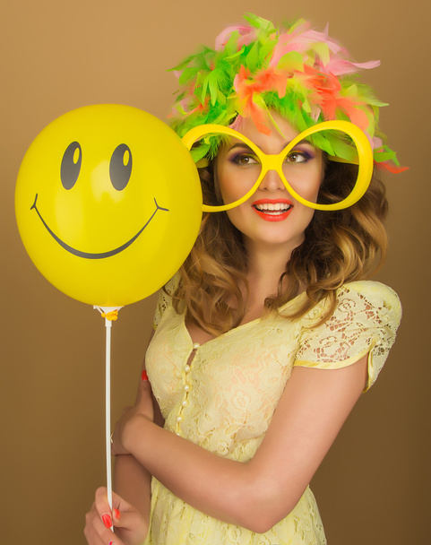Beautiful girl in a bright wig and big glasses holding a balloon - Foto, Imagen