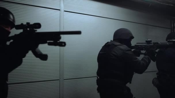 Spezialeinsatzkommandos durchsuchen Zielfernrohre von Gewehren. Soldaten ziehen durch Flur - Filmmaterial, Video