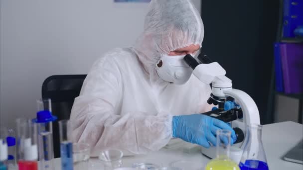 microbioloog bekijkt nieuw virus of bacteriën in microscoop, die in laboratorium werken - Video
