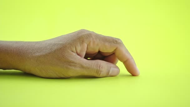 Kézmozdulat az ember kéz jele a várakozás jele, és tegye az ujját Ő vár, vagy gondol valami elszigetelt sárga háttér - Felvétel, videó