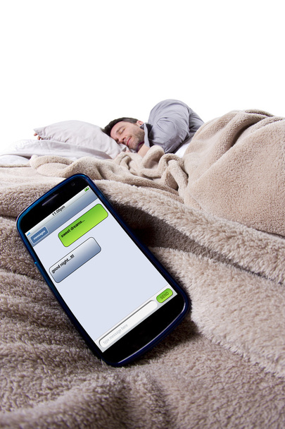 Cell phone screen showing text messages while male is in bed - Foto, Imagem